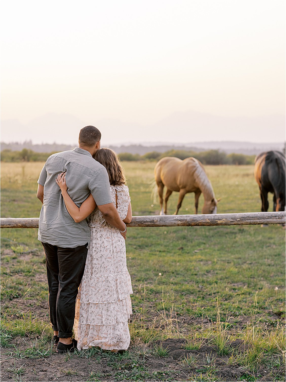 Couple embracing in front of a horse ranch with film wedding photographer Renee Hollingshead
