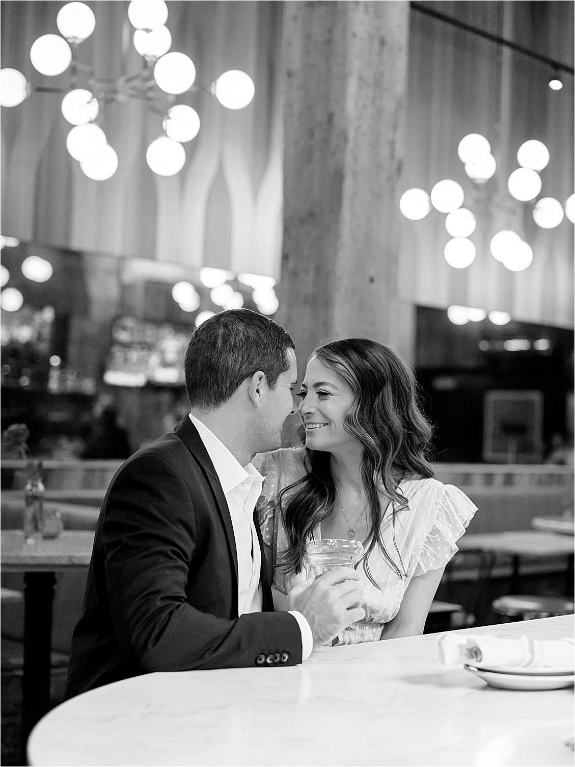 Couple sits at bar of Italian Disco in Fells Point during their engagement session