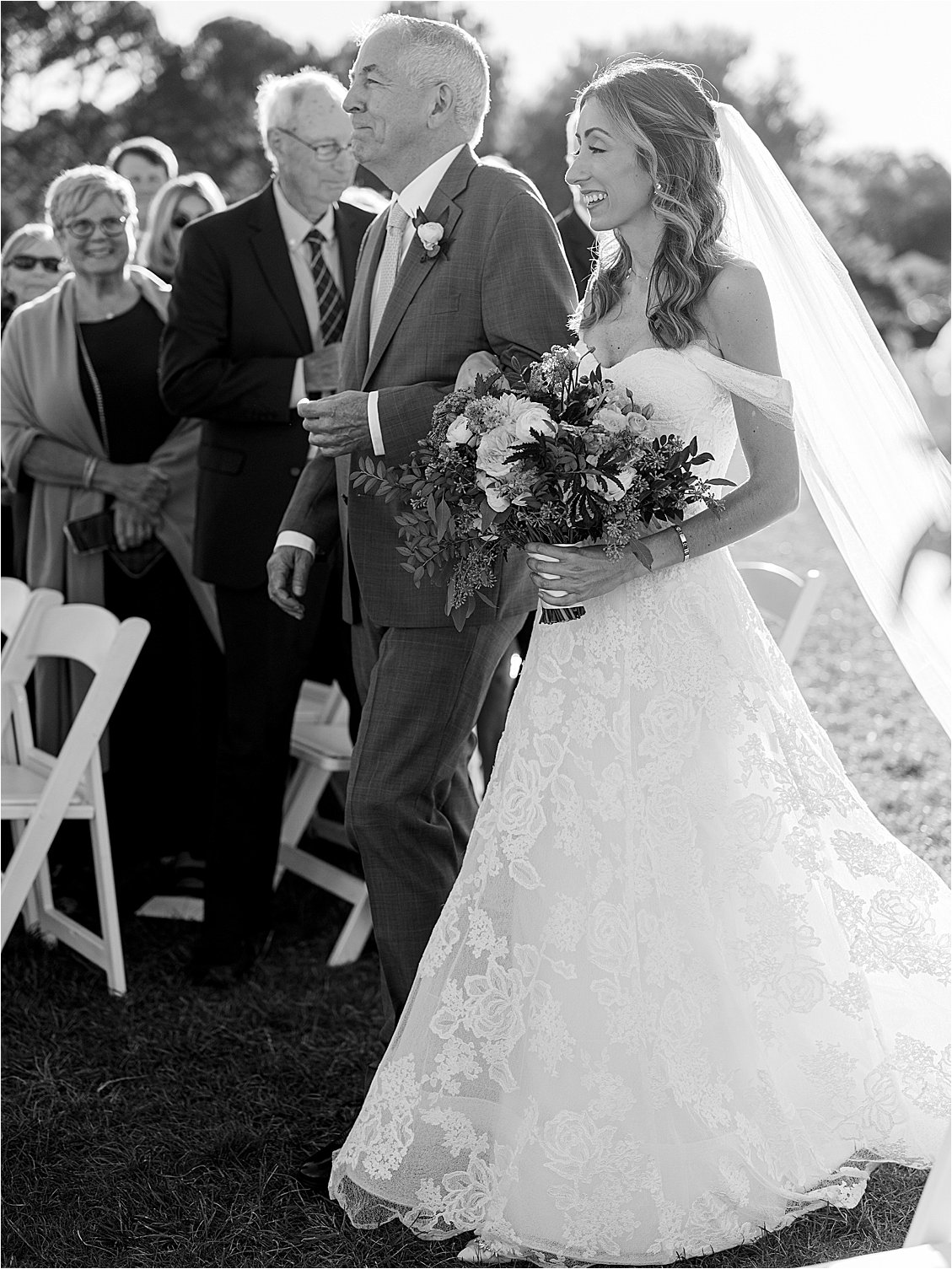 Black and white image of father walking his daughter down the aisle