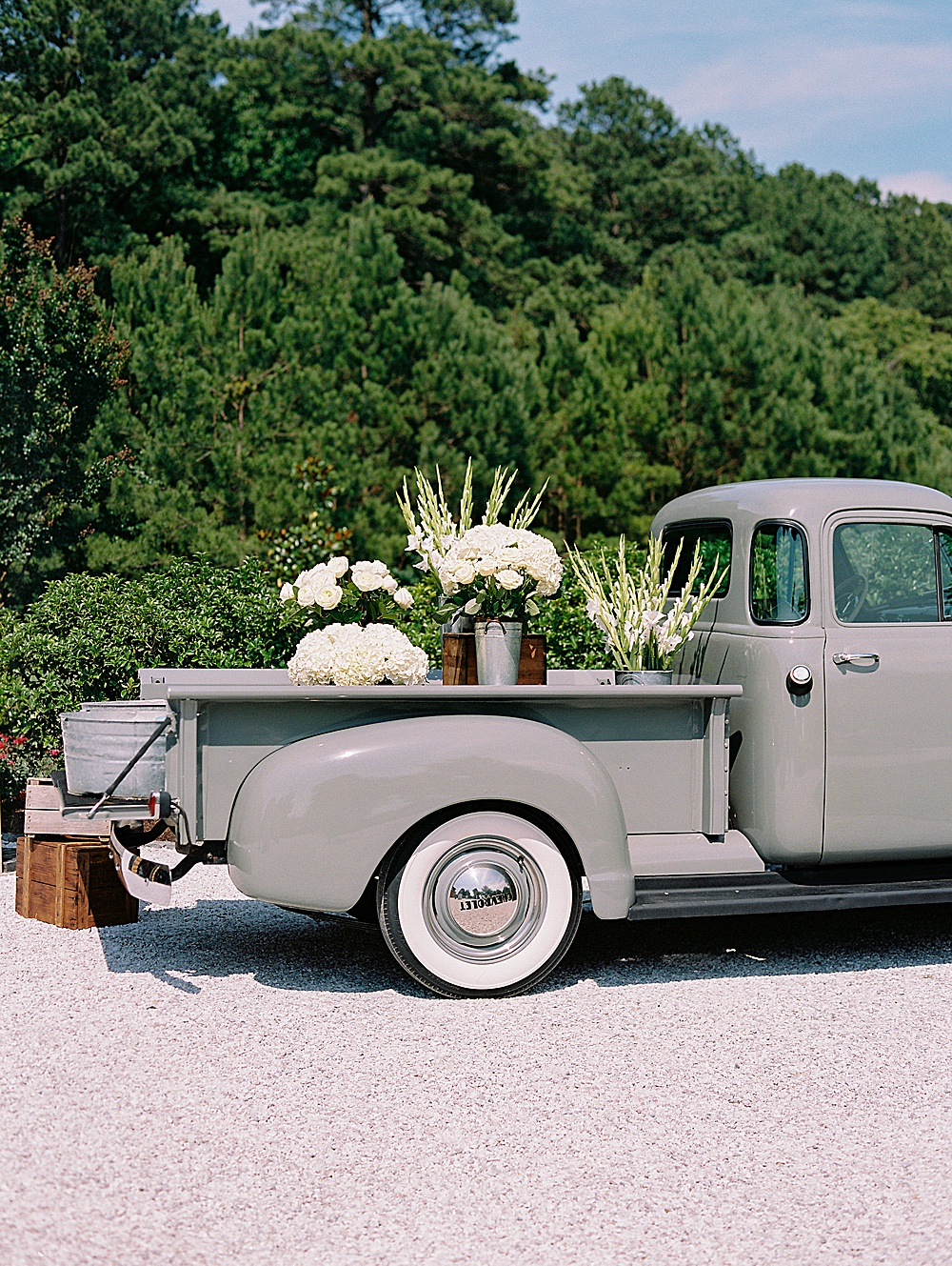 Vintage truck with florals and beverages during cocktail hour at private estate wedding
