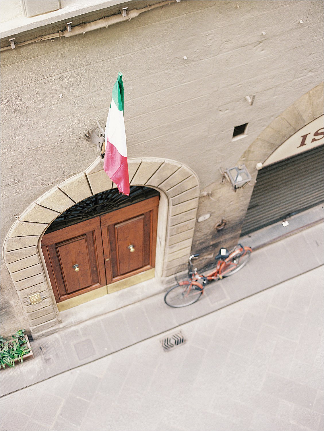 Doorstep with Italian Flag in Florence, Italy on film with destination wedding photographer Renee Hollingshead
