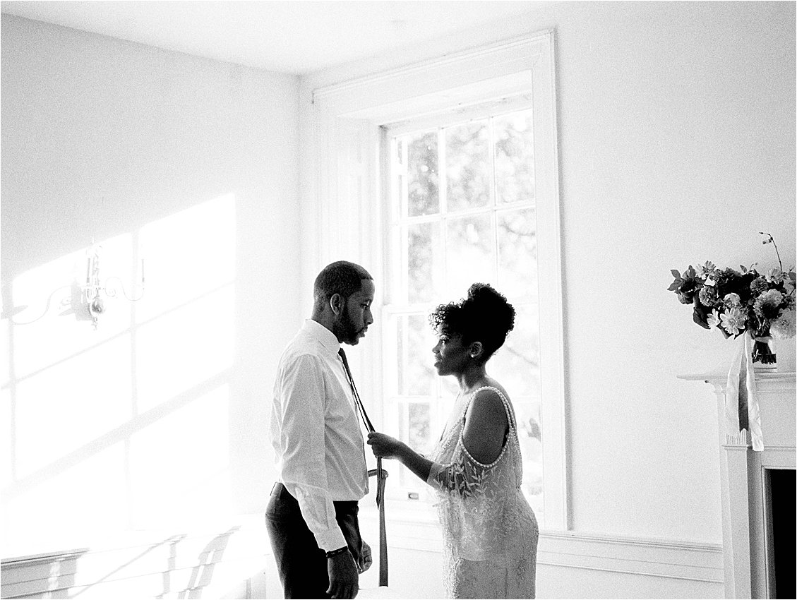 Bride and Groom get dressed together on wedding day photographed by DC Film Wedding Photographer, Renee Hollingshead