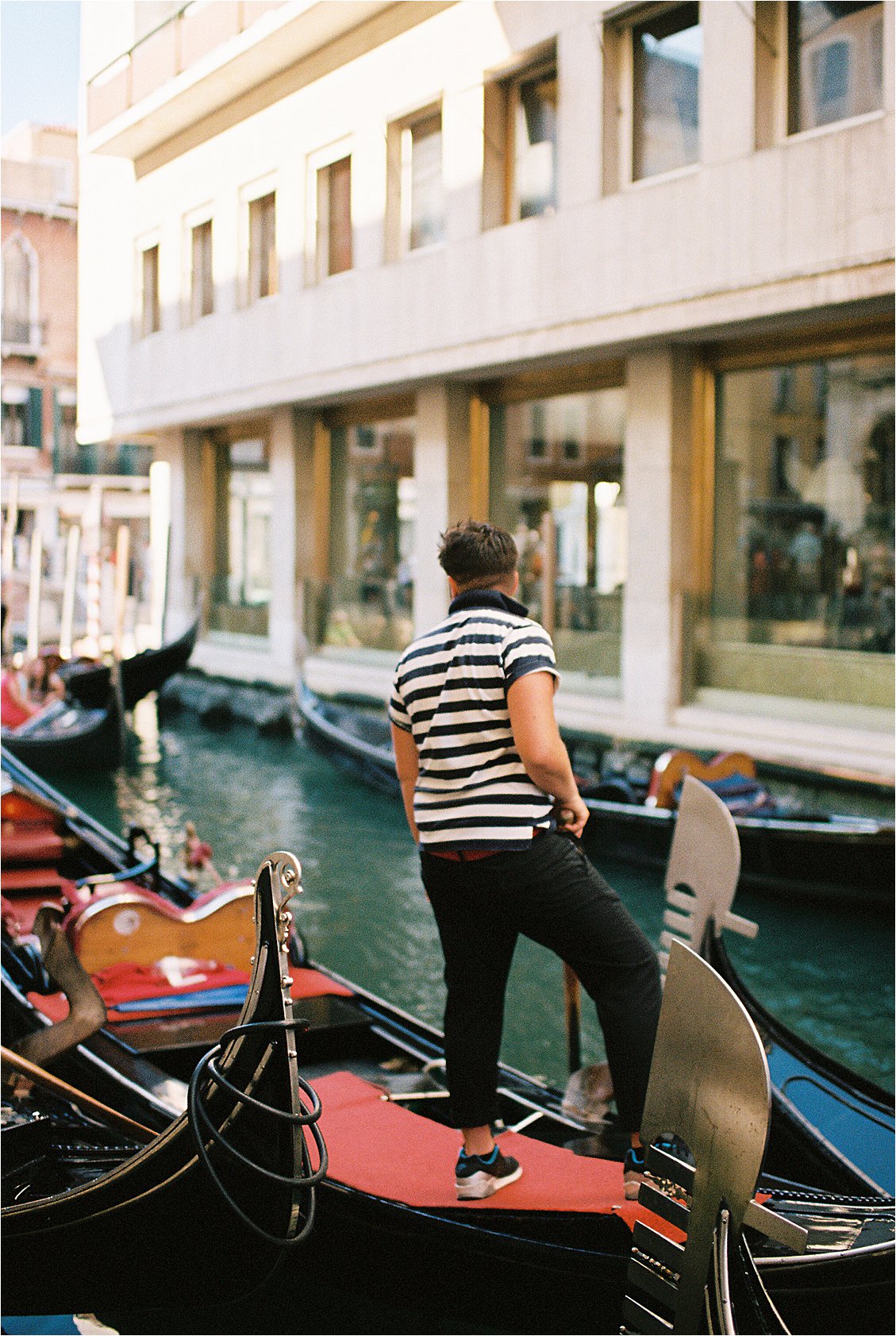Gondelier in Venice, Italy on film by destination wedding photographer Renee Hollingshead