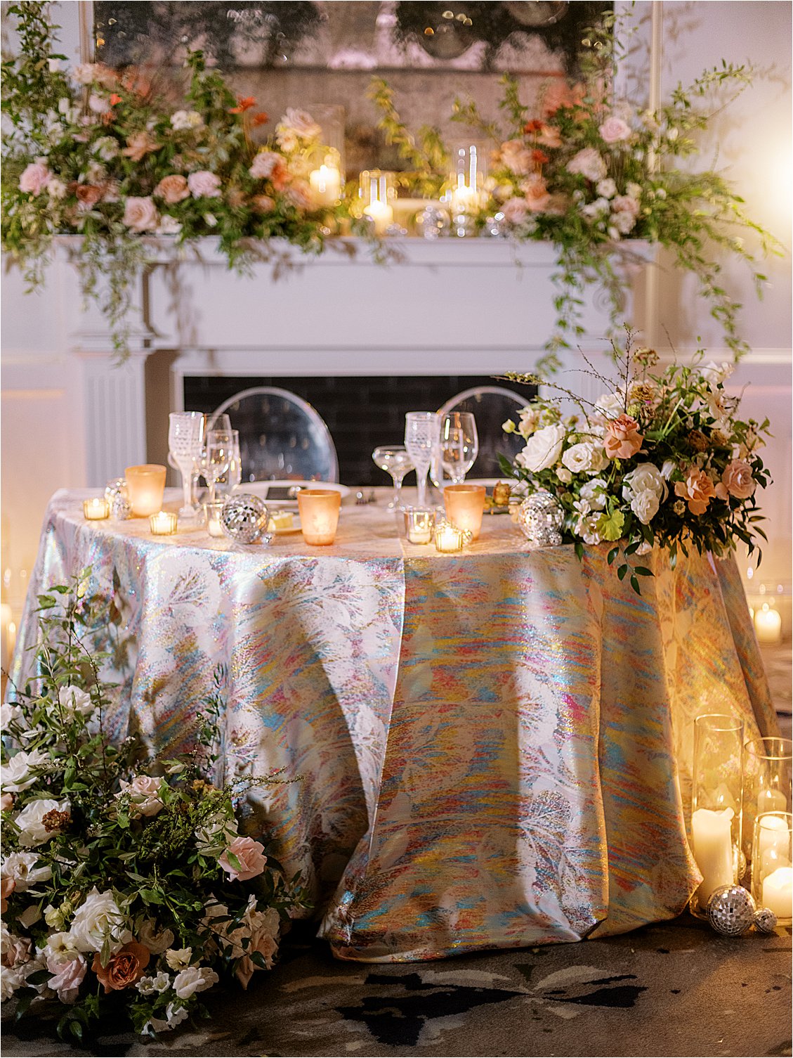 Sweetheart table filled with florals and candlelight with a iridescent rainbow linen for a spring same-sex DC Wedding