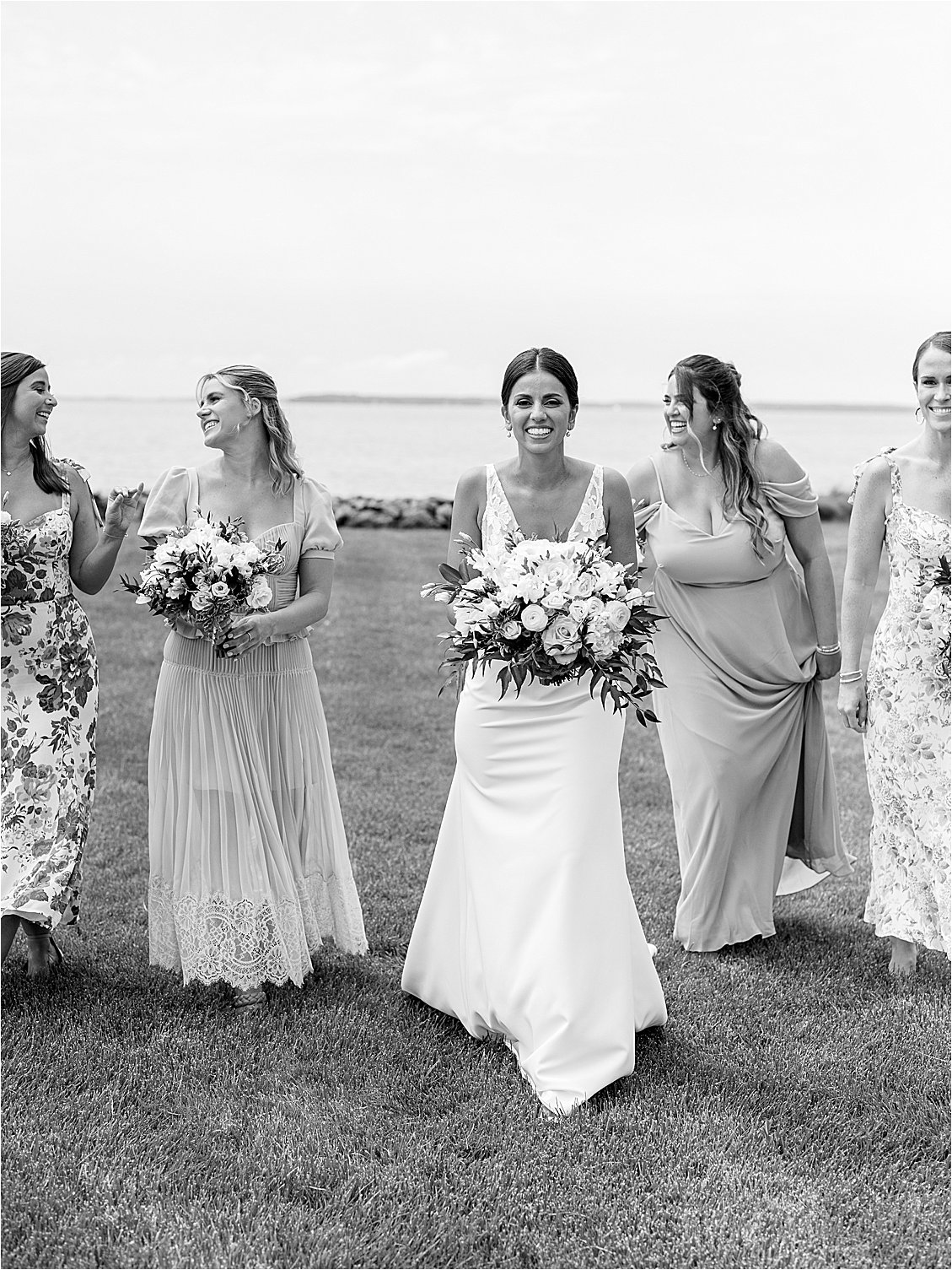 Bride walking with bridesmaids across the lawn overlooking the Chesapeake Bay during a waterfront estate wedding on Maryland’s Eastern Shore.