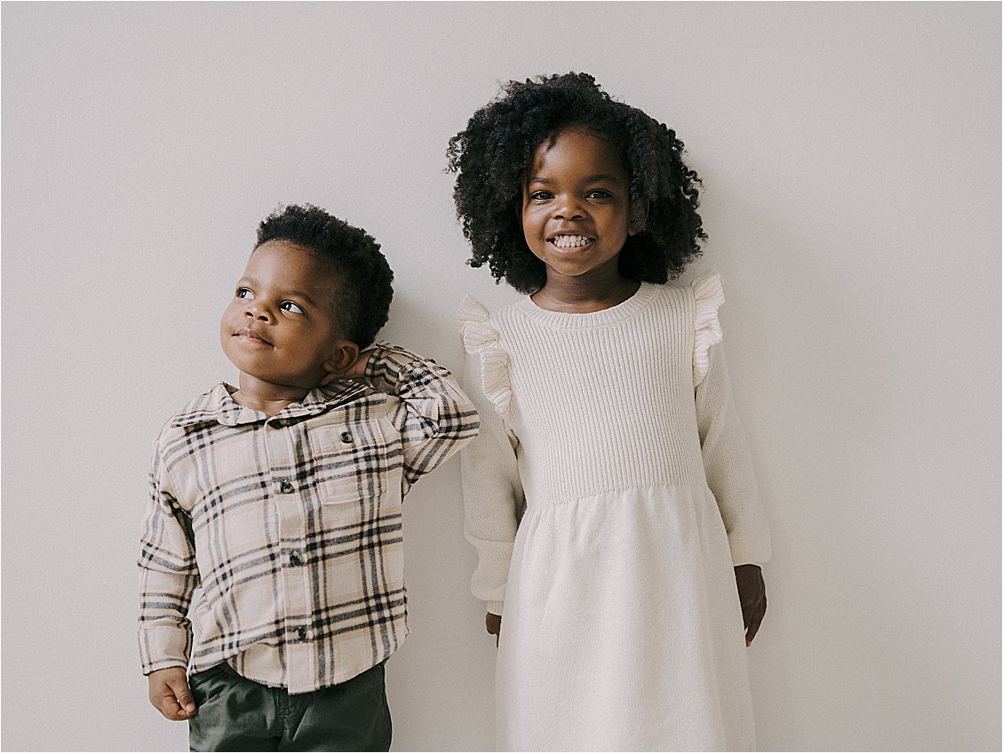 Candid studio portrait of young brother and sister, boy gazing to the side and girl smiling at camera, film family session Annapolis Maryland by Renee Hollingshead Photography