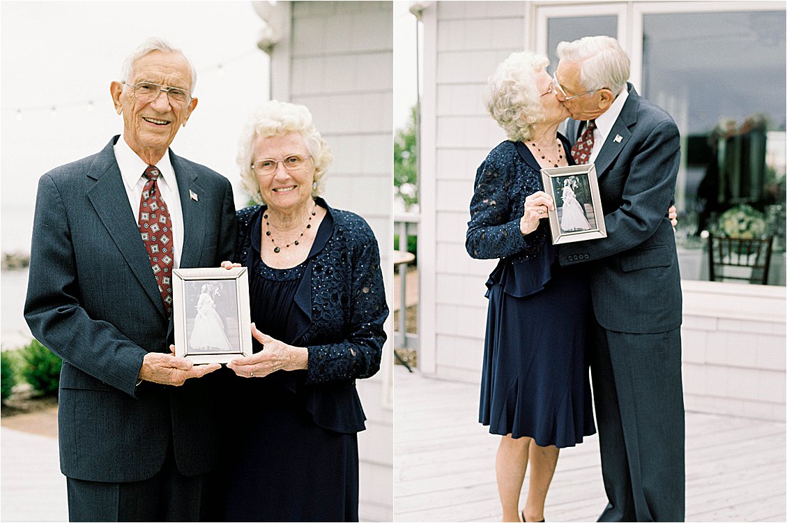 Elderly couple sharing a kiss while holding their original framed wedding photo at a family celebration, film photography by Renee Hollingshead