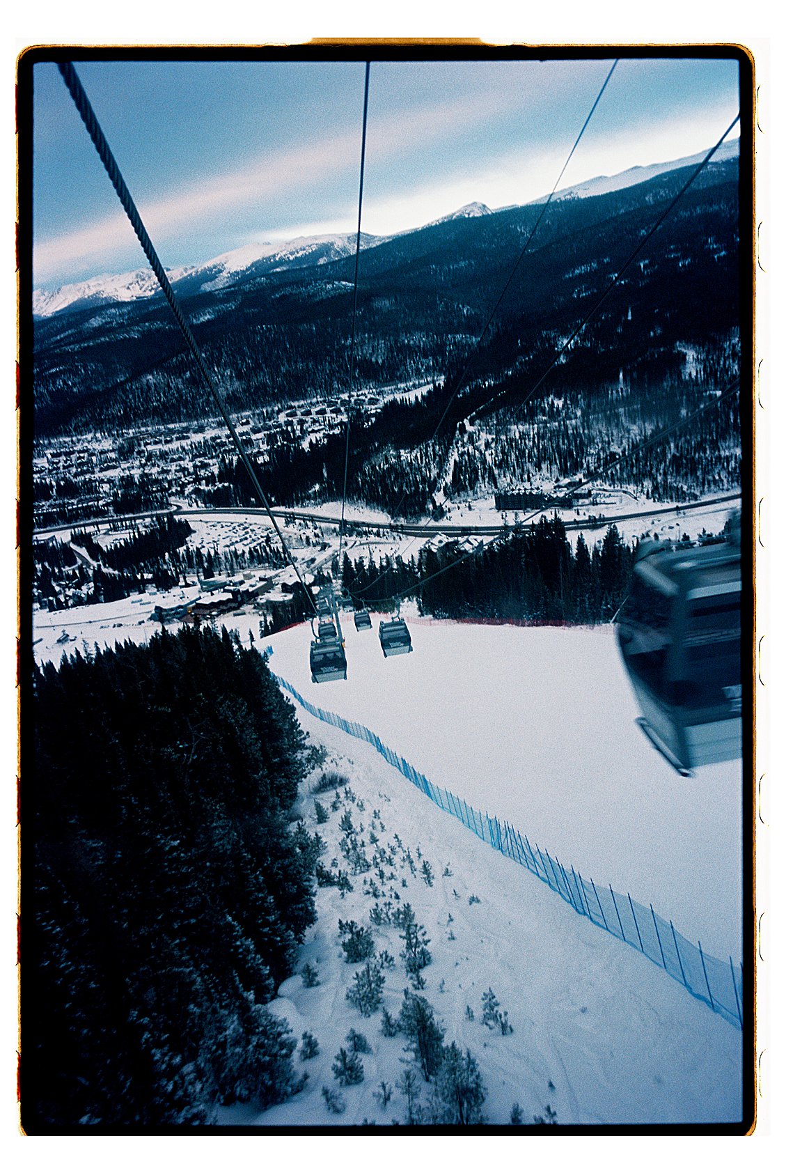 Aerial gondola view over Winter Park Resort Colorado looking down on snowy ski runs, pine forests, and the mountain town below. Film photo by destination photographer Renee Hollingshead on Kodak Portra 400.