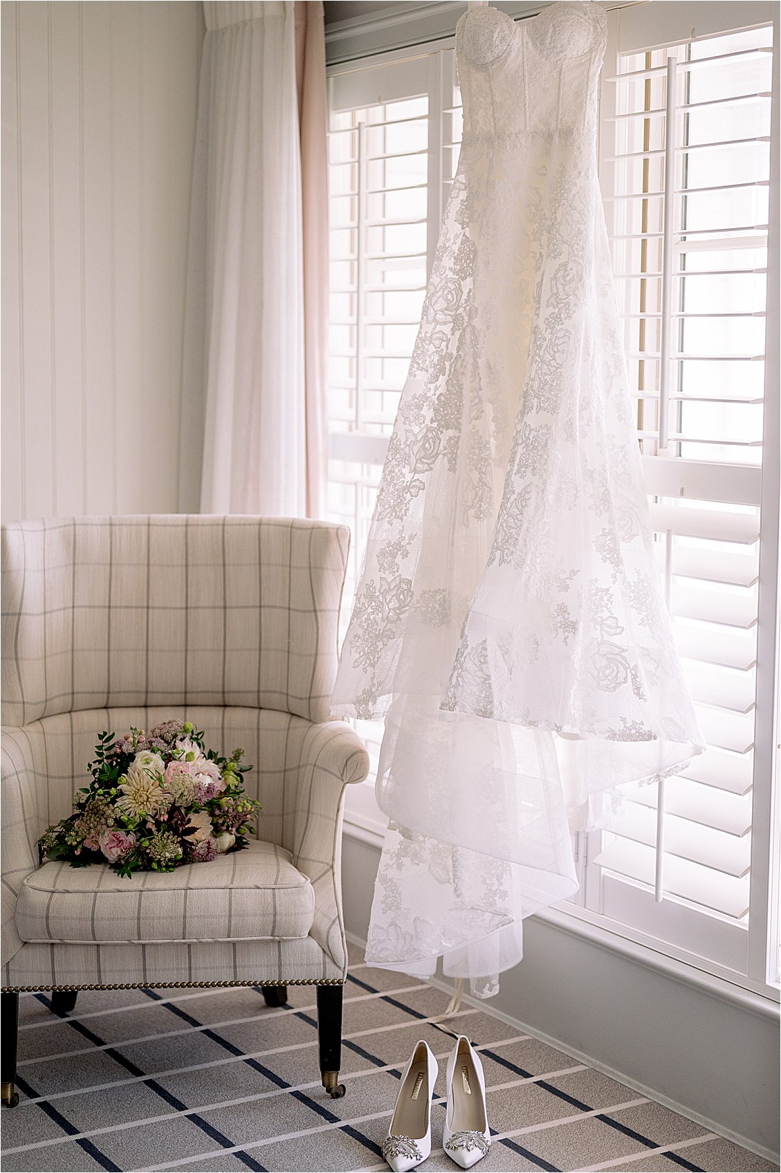 Wedding dress hanging in Inn at Perry Cabin bridal suite with bouquet and bridal shoes, photographed by Renee Hollingshead Photography