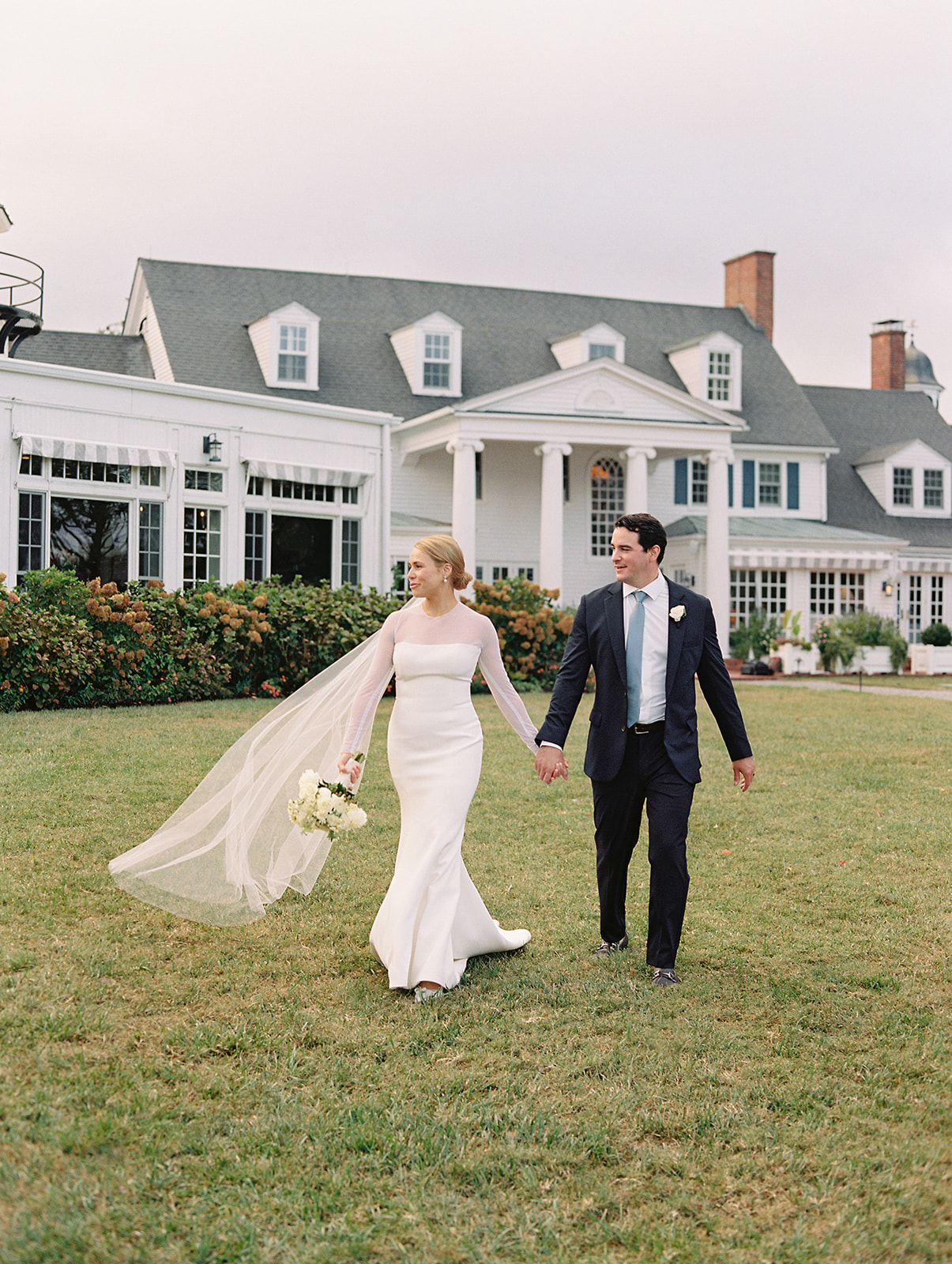 Bride and groom walking on the lawn at Inn at Perry Cabin fall wedding, photographed on film by Renee Hollingshead Photography