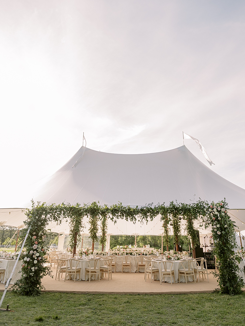 Sailcloth tent wedding reception with lush greenery arch at Inn at Perry Cabin spring wedding, photographed by Renee Hollingshead Photography
