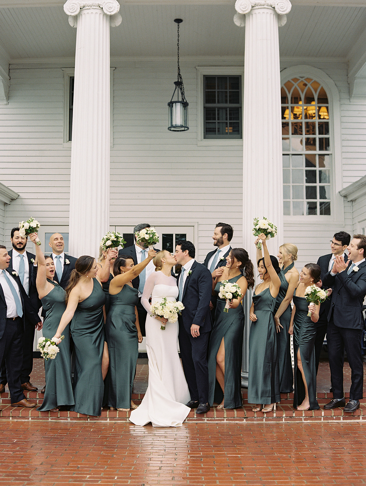 Wedding party celebrating in front of the colonial columns at Inn at Perry Cabin, St. Michaels Maryland, photographed by Renee Hollingshead Photography